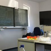 Beim erste Hilfe Kurs. Vor einer beschriebenen Tafel liegen Utensilien und die Referentin spricht.